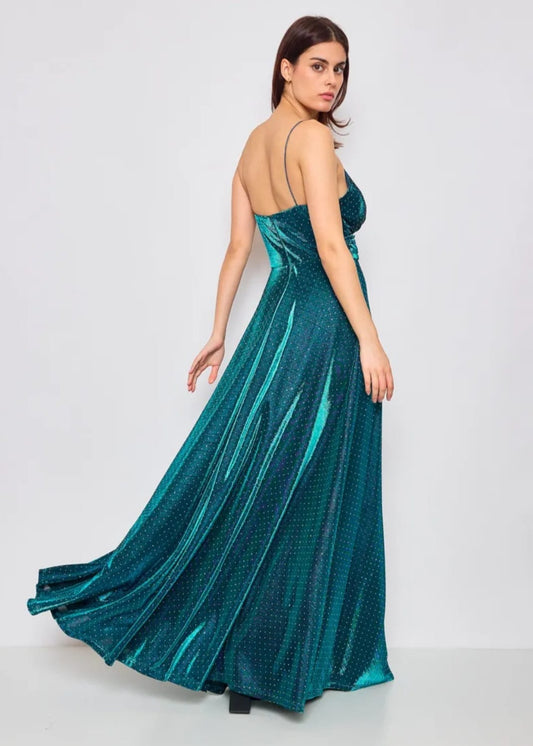 La mannequin porte la robe de soirée Adèle en version bleu turquoise. La robe est longue, évasée et fluide pour un rendu tout en souplesse. Le tissu est irisé et parsemé de tout petit diam's discrets. Elle a des fines bretelles. Cette robe est disponible au showroom à Dijon, à la location ou à l'achat.