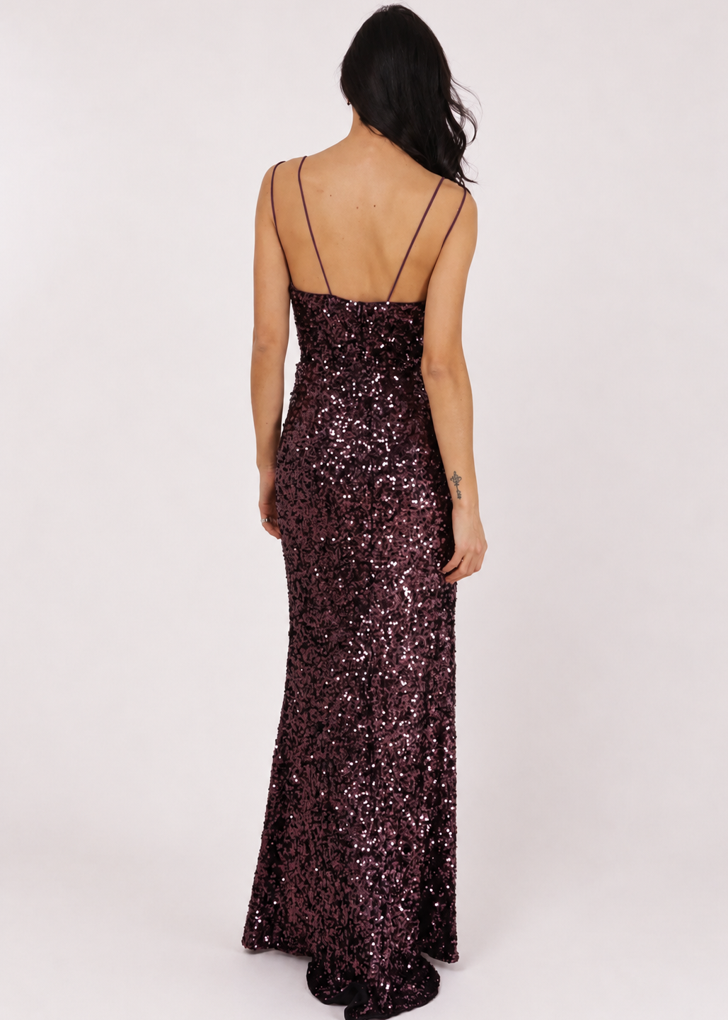 Vue de dos de cette sublime longue robe de soirée entièrement en sequins violet foncé. Disponible à la location et à l'achat au showroom à Dijon, près de Beaune.